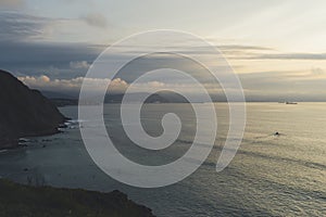 Clouds sky and sunlight sunset on horizon ocean. Mountain on background seascape dramatic atmosphere rays sunrise. Relax view wave