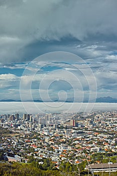 Clouds, sky and top view of city and buildings in landscape, travel destination with skyscraper and outdoor. Urban