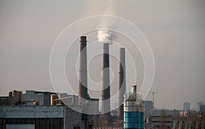 Clouds of smoke from the smokestacks of an industrial plant pollutes the air in a suburban area