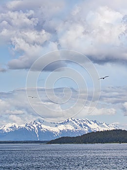 Clouds and snow covered mountains in the Lynn Canal in Southeast Alaska