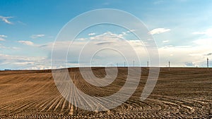 clouds on a sunny summer day over agricultural fields. A beautiful hilly field plowed before sowing various cereals, grain, wheat