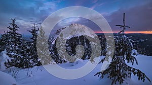 Clouds time lapse fast motion in winter mountains nature with snowy forest trees at frozen Christmas sunrise 4K