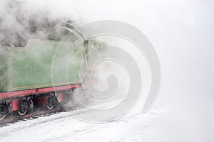 Clouds of vapor around the green steam train.