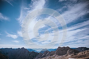 Clouds in the wind; top Zugspitze in the Wetterstein mountain, Experienced people hiking advenure under beautiful sky of Alpen photo