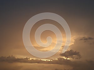 Cloudscape background with dark distinctive cloud shapes and brown golden sky