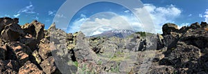 Cloudscape on encrusted volcanic rock and Etna Mount panoramic view, photo