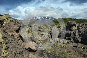 Cloudscape on encrusted volcanic rock and Etna Mount photo