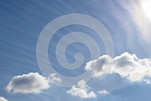 Cloudscape of fluffy clouds and long wispy clouds against a blue sky, as a nature background