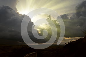 Cloudscape image of dark stormy clouds in blue sky with sun beam. The rays of the sun after the rain. Scenery with the sun`s rays