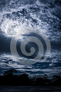 Cloudscape. Nightly sky with bright full moon. Outdoors at night