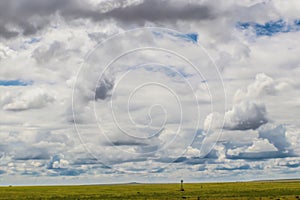 Cloudscape on the plains with windmill in the distance - Big sky country