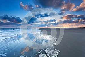 Cloudscape reflected in sea at sunrise