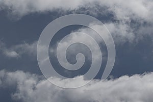 Cloudscape scenery, overcast weather above dark blue sky. Storm clouds floating in a rainy dull day with natural light. White and