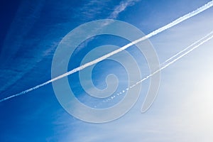 Cloudscape with trail of jet plane on blue sky. Natural background.