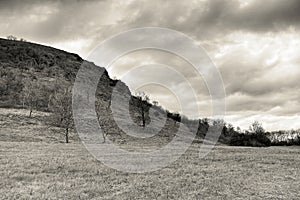 Cloudy afternoon in Czech central mountains landscape area near Mila hill in winter without snow in december 2017 in sepia styliza