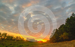 Cloudy autumn morning. Fresh nature. Bright sunrise in the meadow.