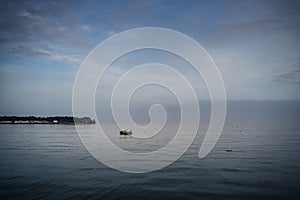 Cloudy blue minimalist seascape with boat