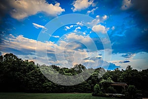 Cloudy blue skies and green silhouette trees