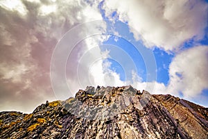 Cloudy blue sky above the top of a mountain