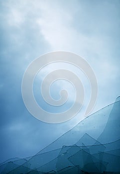 Cloudy blue sky through broken window