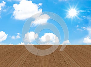 Cloudy blue sky with sun beam and wood floor