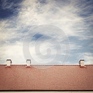 Cloudy blue sky and tiled roof top