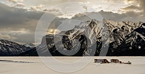 Cloudy colorful skies and winter sunset over mountain peaks at Lake Minnewanka