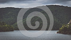 Cloudy day at a dam lake between the hills of Cluj County