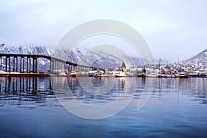 Cloudy day in famous north town Tromso, Norway. View of the fjord with houses