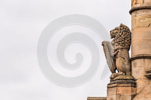 Cloudy day view stone lion symbol in gothic architecture in england