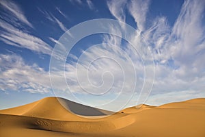Cloudy desert sky with sand dunes