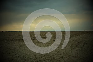 Cloudy evening sky over a plowed farm field. Landscape. Vignette