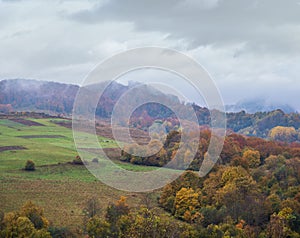 Cloudy and foggy day autumn mountains scene. Peaceful picturesque traveling, seasonal, nature and countryside beauty concept scene