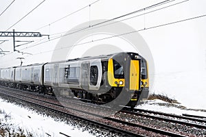 Cloudy foggy winter day view of Train on UK Railroad in England. Emma storm railway landscape.