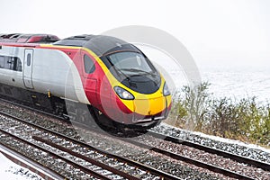 Cloudy foggy winter day view of Train on UK Railroad in England. Emma storm railway landscape.