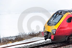 Cloudy foggy winter day view of Train on UK Railroad in England. Emma storm railway landscape.