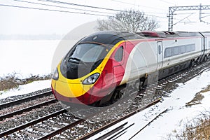 Cloudy foggy winter day view of Train on UK Railroad in England. Emma storm railway landscape.