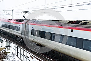 Cloudy foggy winter day view of Train on UK Railroad in England. Emma storm railway landscape.