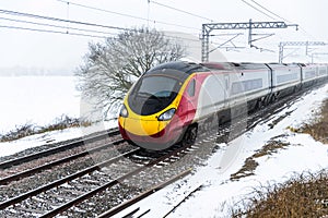 Cloudy foggy winter day view of Train on UK Railroad in England. Emma storm railway landscape.