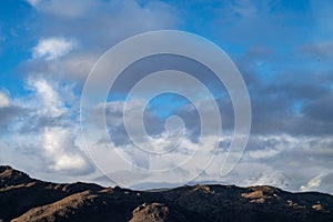 Cloudy November sky over snowy mountains and hills, Eastern Sierra Nevadas, California, USA