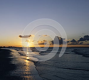 Cloudy orange sunset over sea water