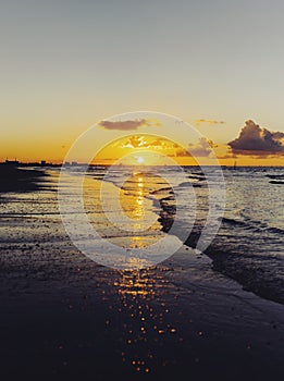 Cloudy orange sunset over sea water, sunset over sea waves.