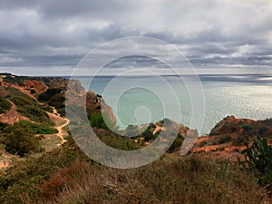 A cloudy sea shore with zigzagging walking paths