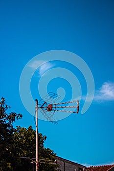 cloudy skies and an antenna mast, trees are lush green, Sky is blue