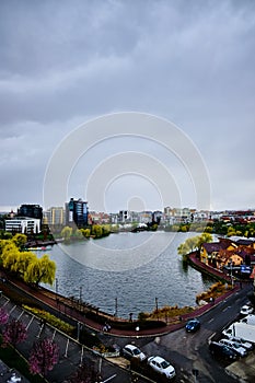 Cloudy sky in autumn, over a city park lake in Cluj-Napoca, Romania with a skyline in the background