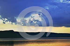 Cloudy sky and big lake near the mountains