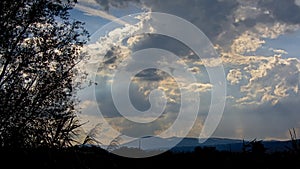 Cloudy sky in the evening light over silhouette of Romanian mountain landscape
