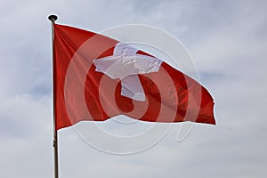 Cloudy sky and the national flag of Switzerland