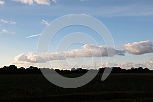 A cloudy sky over a cultivated land and trees in geeste emsland germany