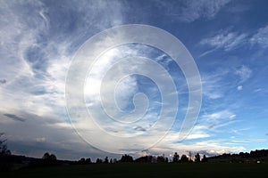 A cloudy sky over a forest and a small town